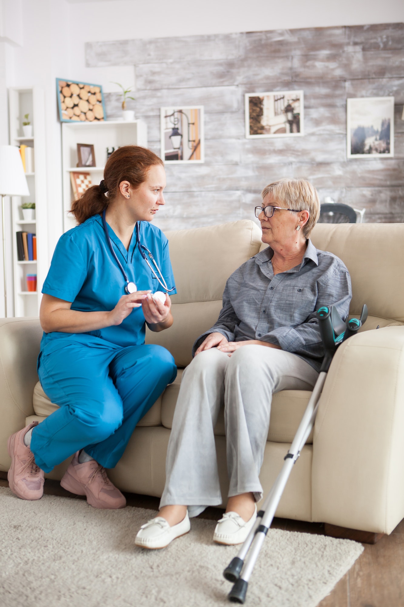 female-nurse-sitting-on-couch-with-senior-woman.jpg